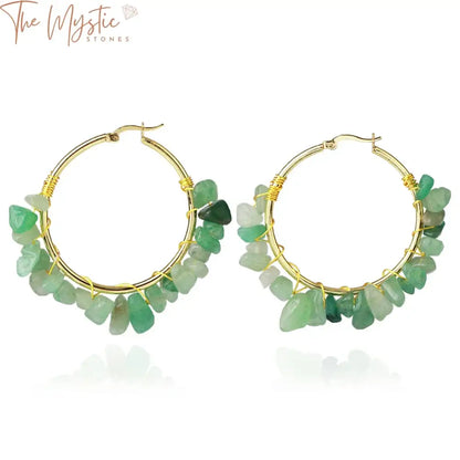 A pair of luxury hoop earrings featuring gold-colored wire wrapping around irregularly shaped pink crystal chip beads.