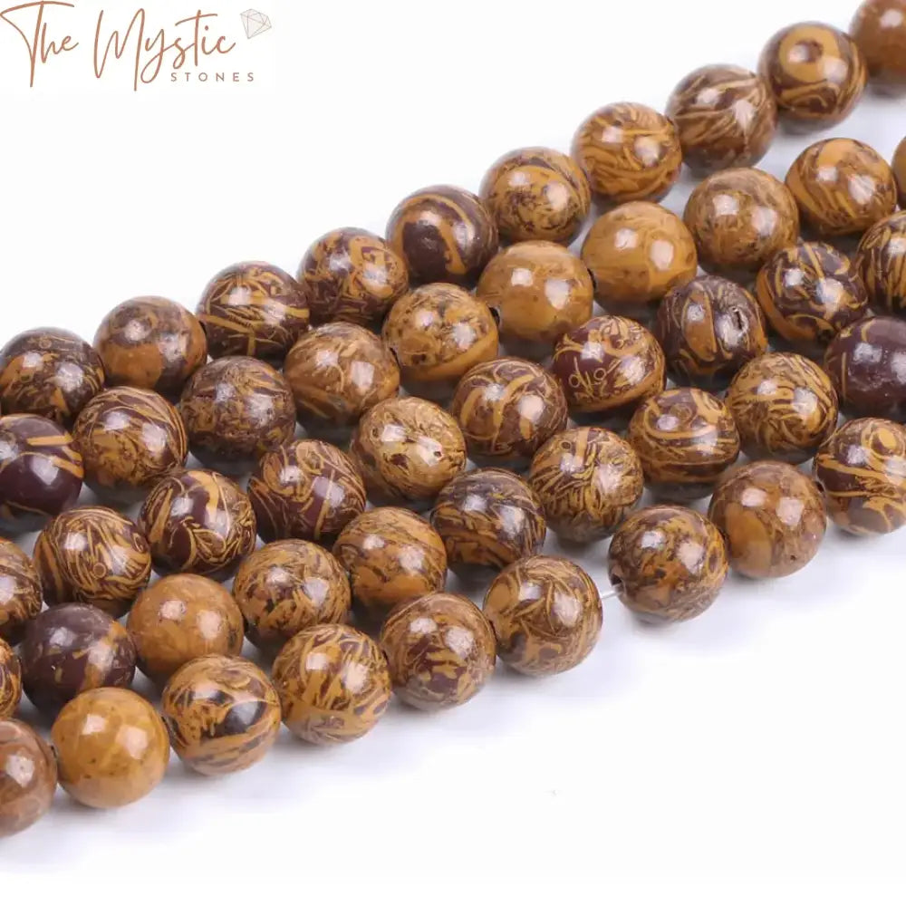 A close-up image of natural stone loose beads, known as Golden Silk Jades, used for jewelry making.