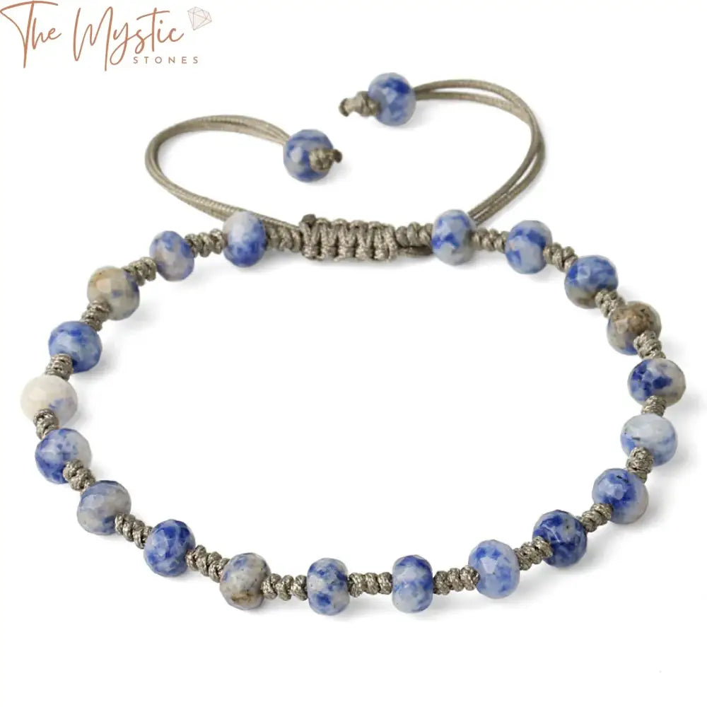 A braided bracelet featuring faceted 6mm round natural stone beads made of crystal quartz in varying shades of gray.