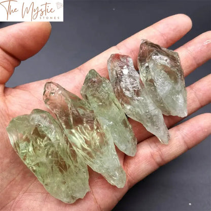 A natural green crystal wand with a pointed tip, made from clear quartz, featuring intricate mineral formations.