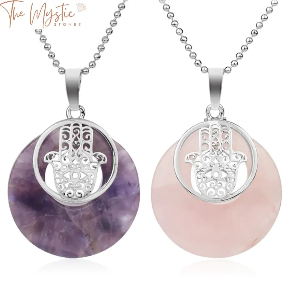 A circular stone crystal pendant featuring an intricate design of the Fatima Hamsa Hand, attached to a delicate chain.