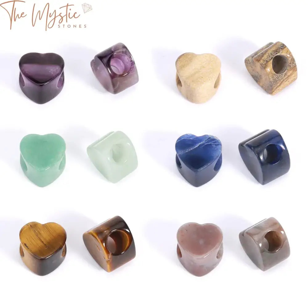 Five natural stone heart beads, each with a large hole, displayed in various colors and patterns.