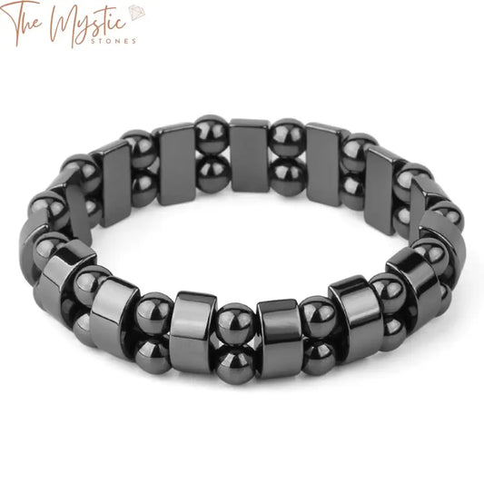 A close-up image of a magnetic hematite bracelet featuring smooth, glossy, spherical natural stone beads strung together.