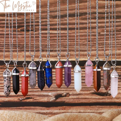 A collection of hexagonal bullet crystal necklaces are displayed, each featuring a natural gemstone pendant.