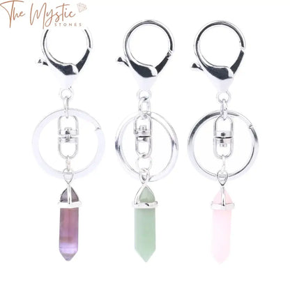 A set of three natural stone keychains, each featuring a hexagonal prism point crystal pendant.