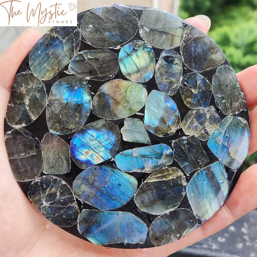 A polished labradorite disc with iridescent hues of blue, green, and gold.