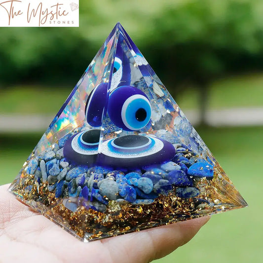 A pyramid-shaped resin sculpture featuring blue evil eye designs.