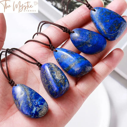 A single rough lapis lazuli stone pendant with a polished surface, showcasing deep blue hues speckled with gold flecks.