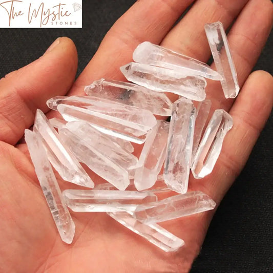 A clear quartz crystal point, measuring approximately 100g, stands upright on a plain background.