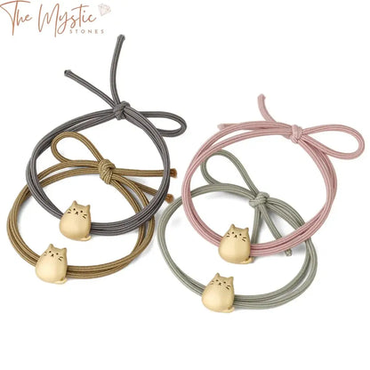 A collection of pastel-colored elastic hair bands featuring small, cute lucky cat charms.