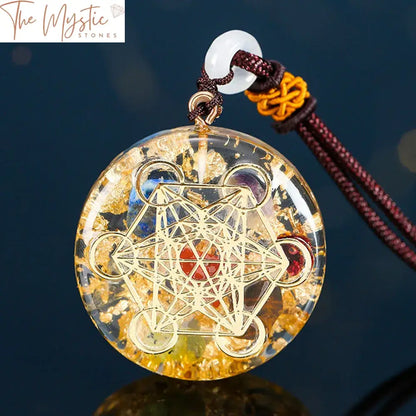 A round pendant featuring a Metatron Cube design made from gold foil, set within a clear resin.