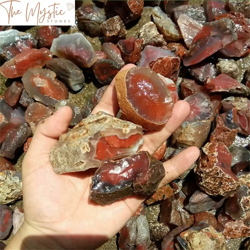 A collection of rough, unpolished carnelian stones scattered on a flat surface.