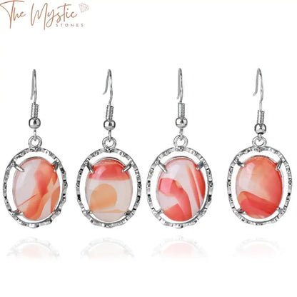 A pair of oval-shaped agate stone earrings with a mix of natural hues, set in a metal frame with ear hook attachments.