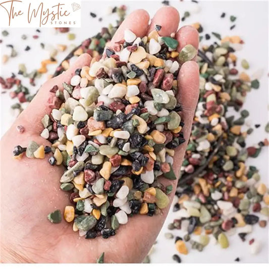 A close-up image of small, colorful natural crystal gravel stones in varying shades of pink, purple, and white.