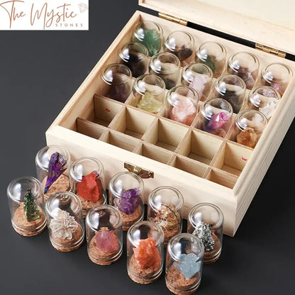 A wooden box kit contains 25 small glass jars, each filled with a different natural crystal or mineral specimen.