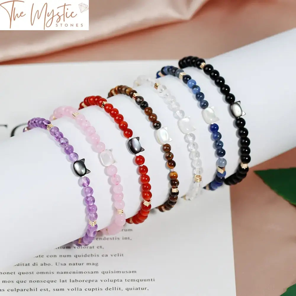 A colorful stretch bracelet made of natural stone beads, featuring a cute cat charm.