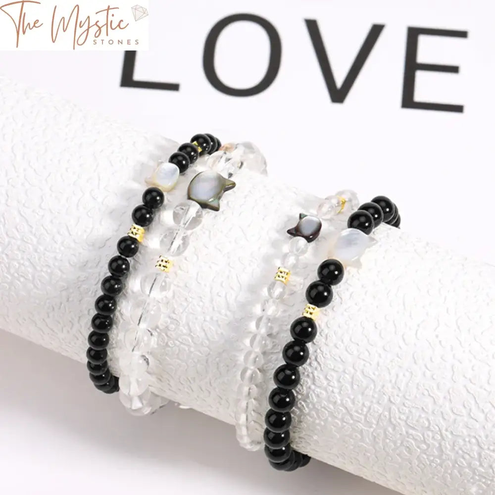 Two bracelets made of natural stones, each featuring a cute cat charm.