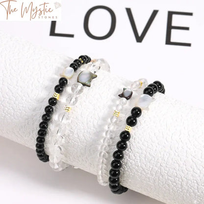 Two bracelets made of natural stones, each featuring a cute cat charm.