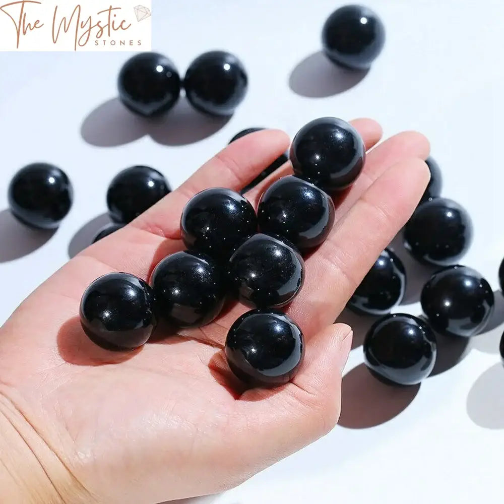 Five natural obsidian gemstone spheres ranging in size from 20-25mm are displayed in the image.