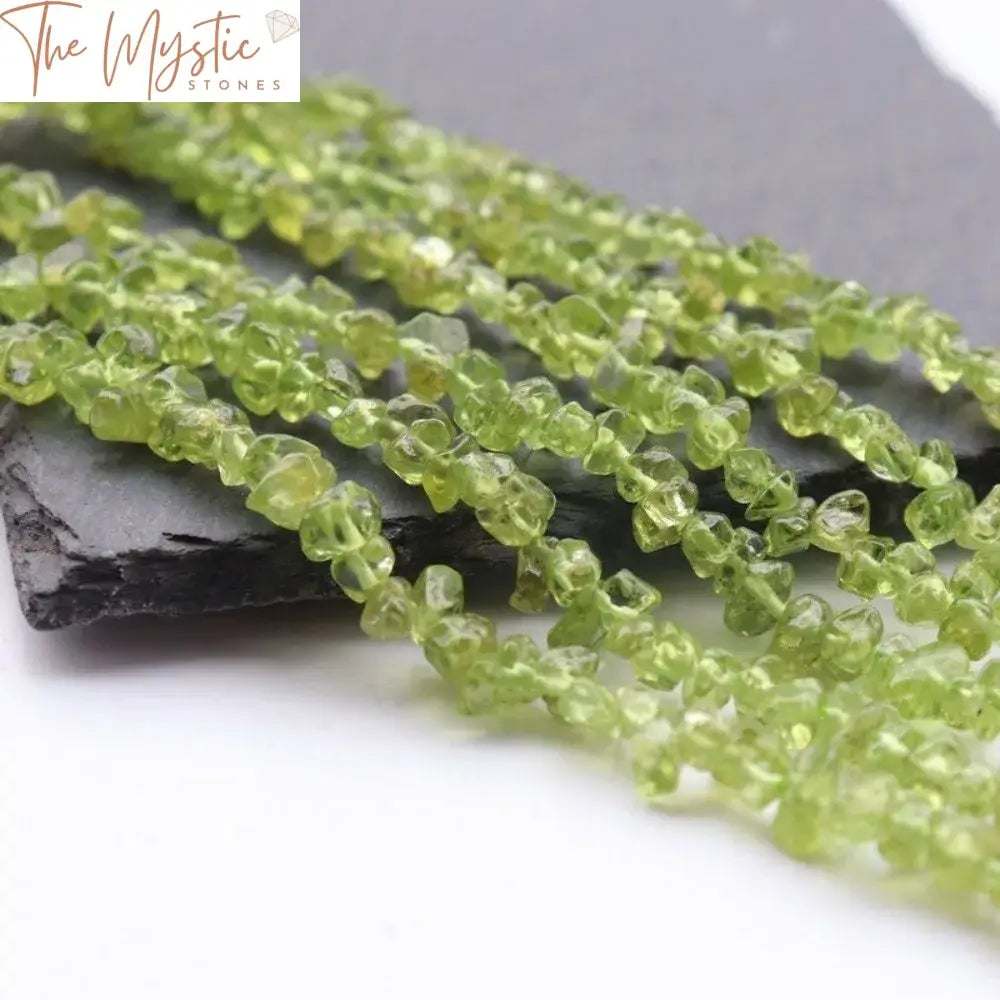 A close-up image of natural peridot chips, showcasing their irregular shapes and vibrant olive green hues.