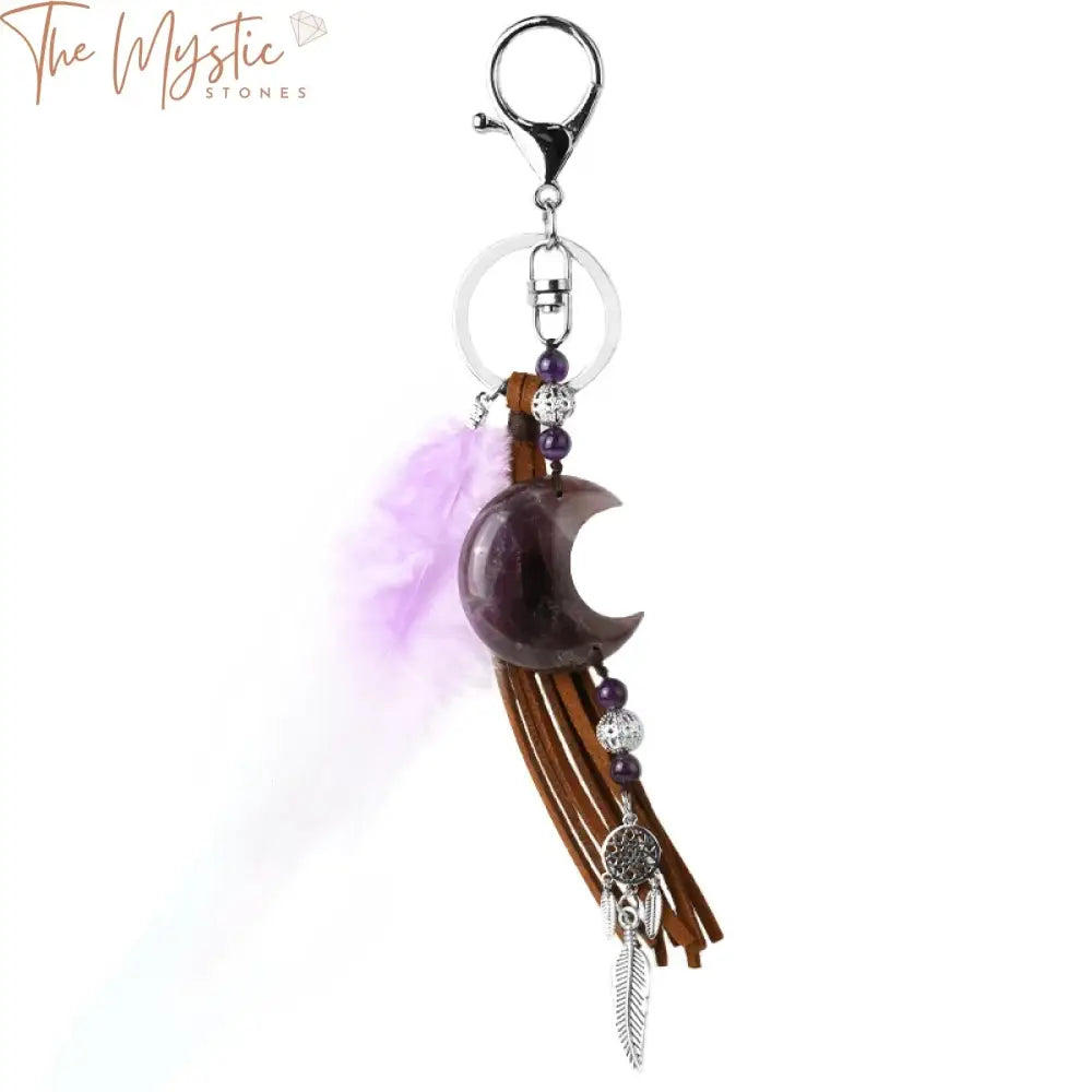 A dream catcher keychain featuring a natural crystal stone with a pink moon design, adorned with tassels.