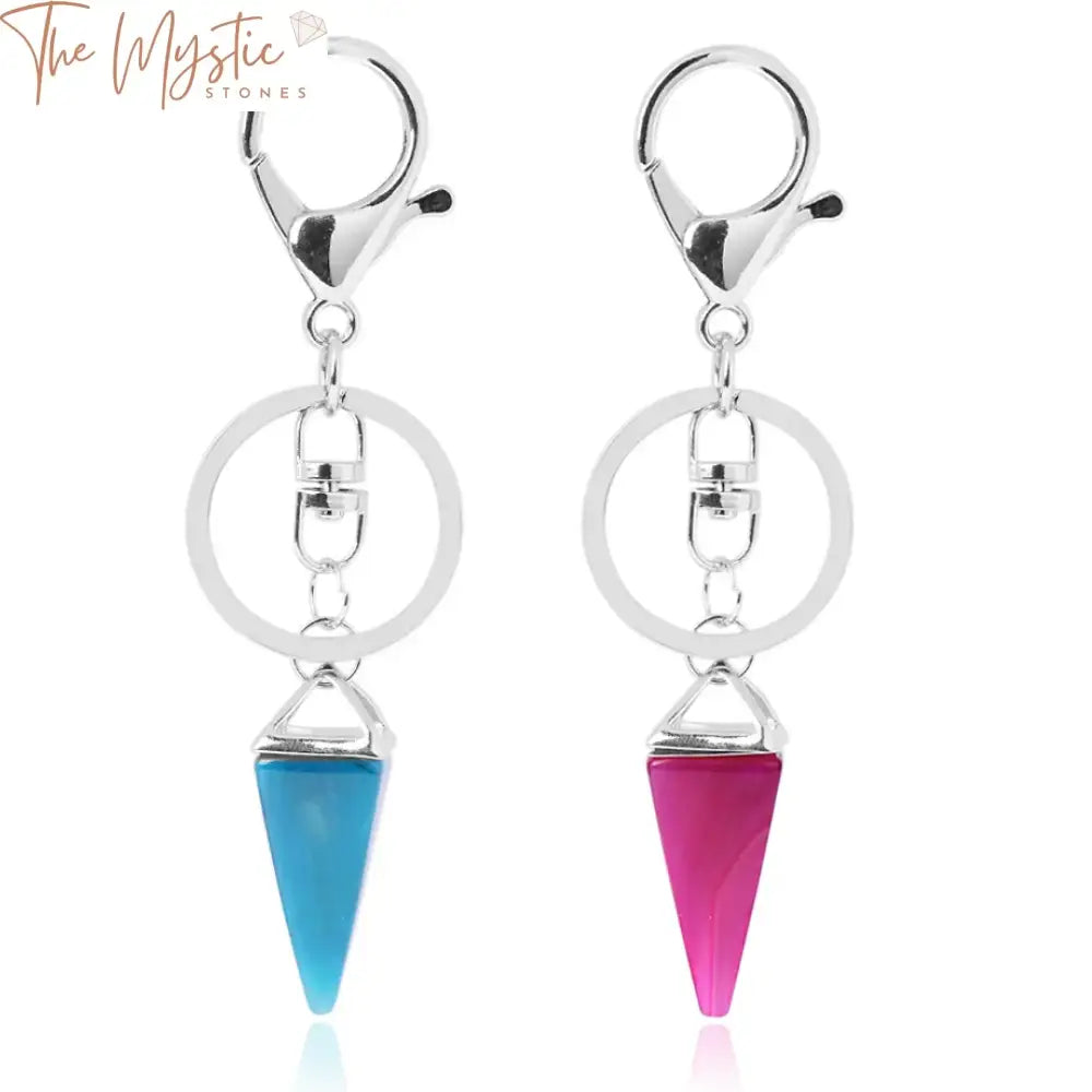 A collection of keychains featuring pyramid-like charms made from natural stone, specifically pink quartz and green stones.