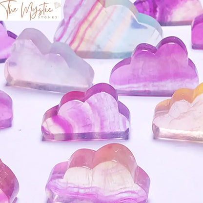 A vibrant crystal carving shaped like a cloud, made from natural rainbow fluorite.