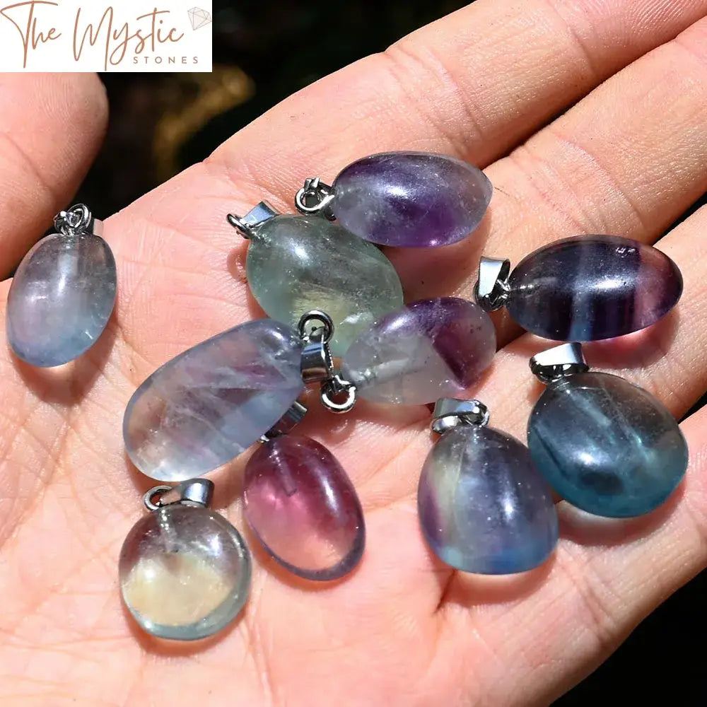 A collection of vibrant rainbow fluorite pendants in an assortment of irregular, tumbled shapes.