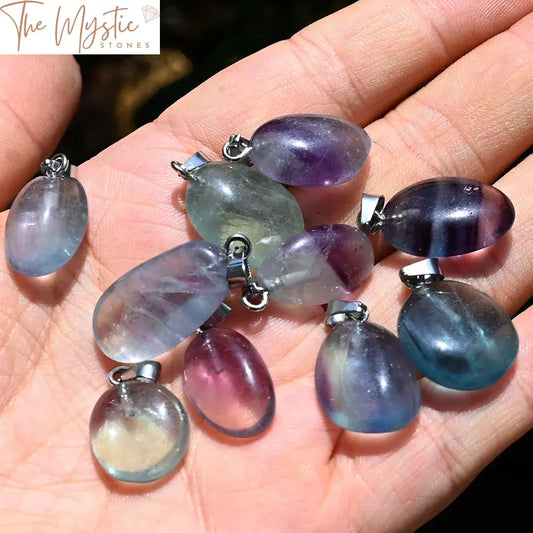 A collection of vibrant rainbow fluorite pendants in an assortment of irregular, tumbled shapes.