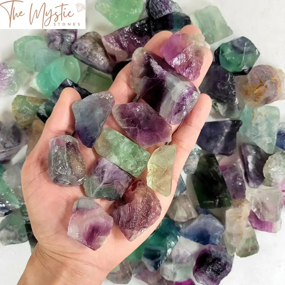 A collection of natural raw rainbow fluorite crystals displayed on a soft fabric surface.