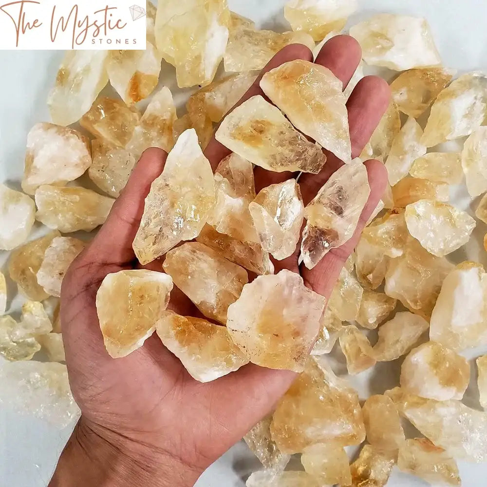 A collection of raw citrine crystal chunks in various sizes, displaying their natural yellow-orange hues.