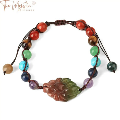 A beaded bracelet featuring stones in various colors representing the seven chakras, with a fox-shaped pendant charm.