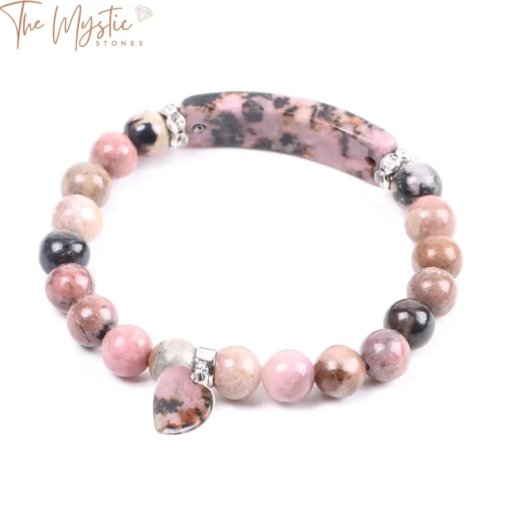 A bracelet made of round rhodonite beads in shades of pink and black, with a central heart-shaped rhodonite stone.