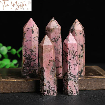 A polished Rhodonite crystal tower with a 6-faceted hexagonal point, displaying deep pink and black patterns.