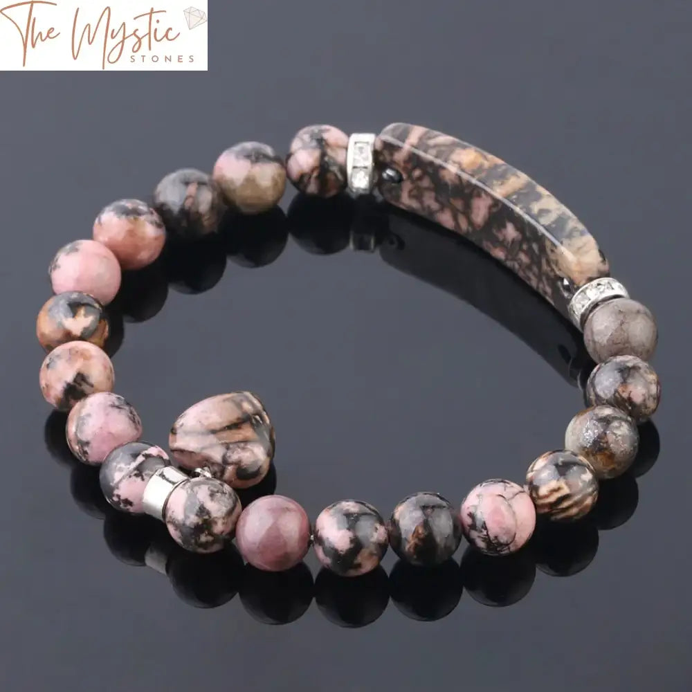 A natural stone crystal bracelet featuring polished rhodonite beads, known for their pink and black marbled appearance.