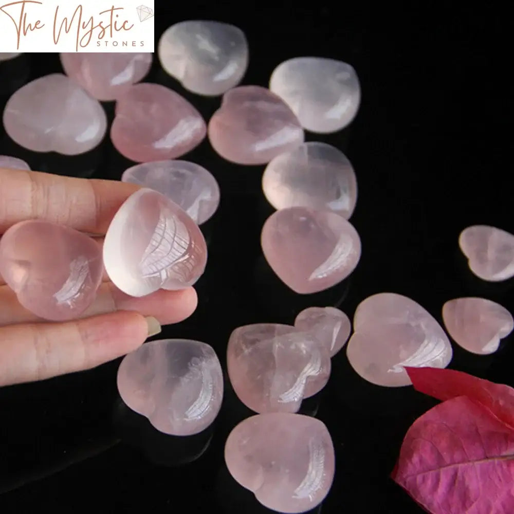 Ten heart-shaped natural rose pink quartz crystals are arranged in a neat formation.