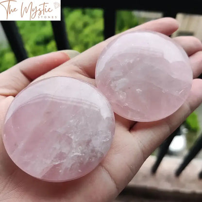 A round, polished crystal with a soft pink hue, representing rose quartz.