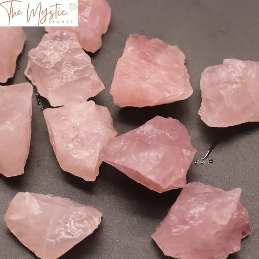 A pile of natural rose quartz crystal stones, characterized by their irregular shapes and soft pink hues.