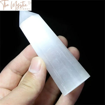 A single natural Selenite Quartz obelisk standing upright on a neutral background.