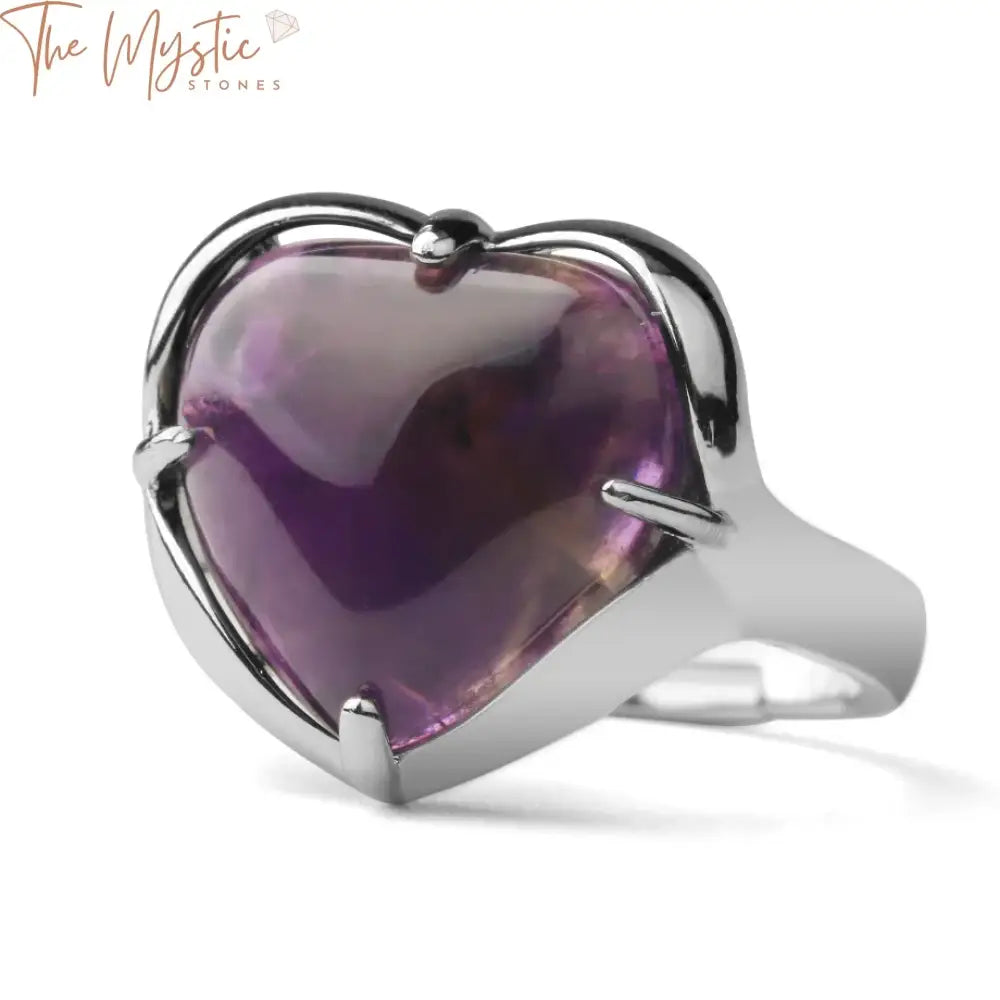 A silver-colored adjustable ring featuring a vibrant love heart-shaped crystal stone at its center, designed for women.