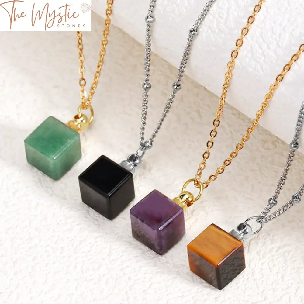 A close-up image of a natural stone perfume necklace featuring a square pendant in the shape of a cube.