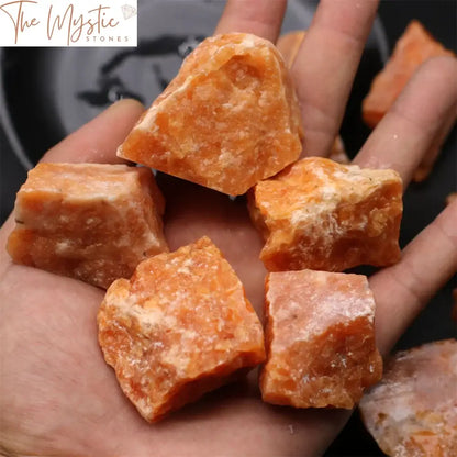 A natural raw sunstone crystal with irregular shapes sits among other rough mineral specimens.