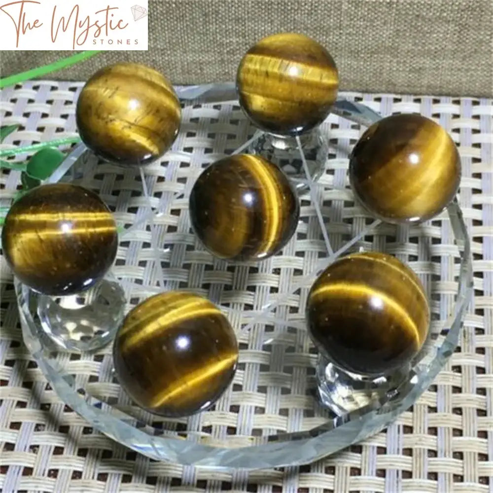 A natural Tiger Eye stone crystal ball set displayed on a Seven Star Array stand.