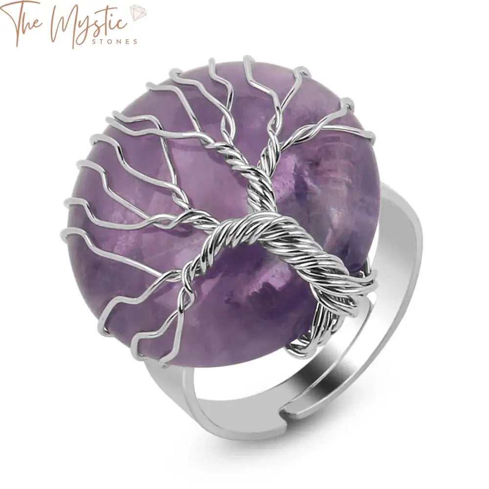 A round cabochon ring featuring a natural stone encased in a Tree of Life wire wrap design.