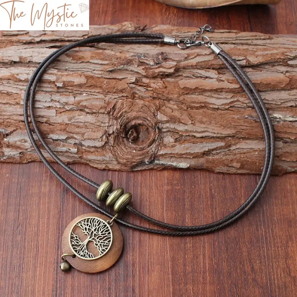 A wooden pendant intricately carved with the Tree of Life design, hanging from a rope layer necklace.