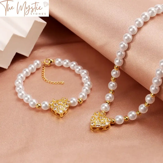 A vintage luxury jewelry set featuring a gold-colored heart pendant with imitation pearls.