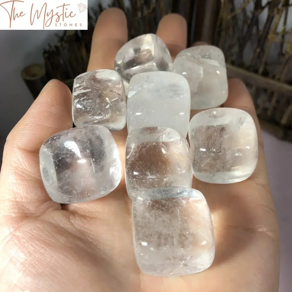 A single larger polished natural white crystal square tumble, made of quartz, displayed on a neutral background.