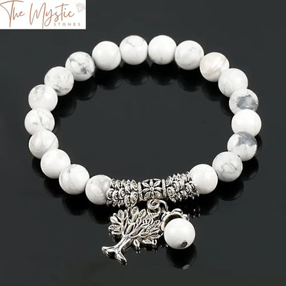 A bracelet made of round white howlite stone mala beads featuring a sizable Tree of Life charm.