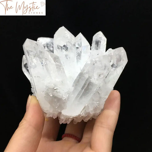 A collection of natural, sparkling white phantom quartz crystals forming a cluster.