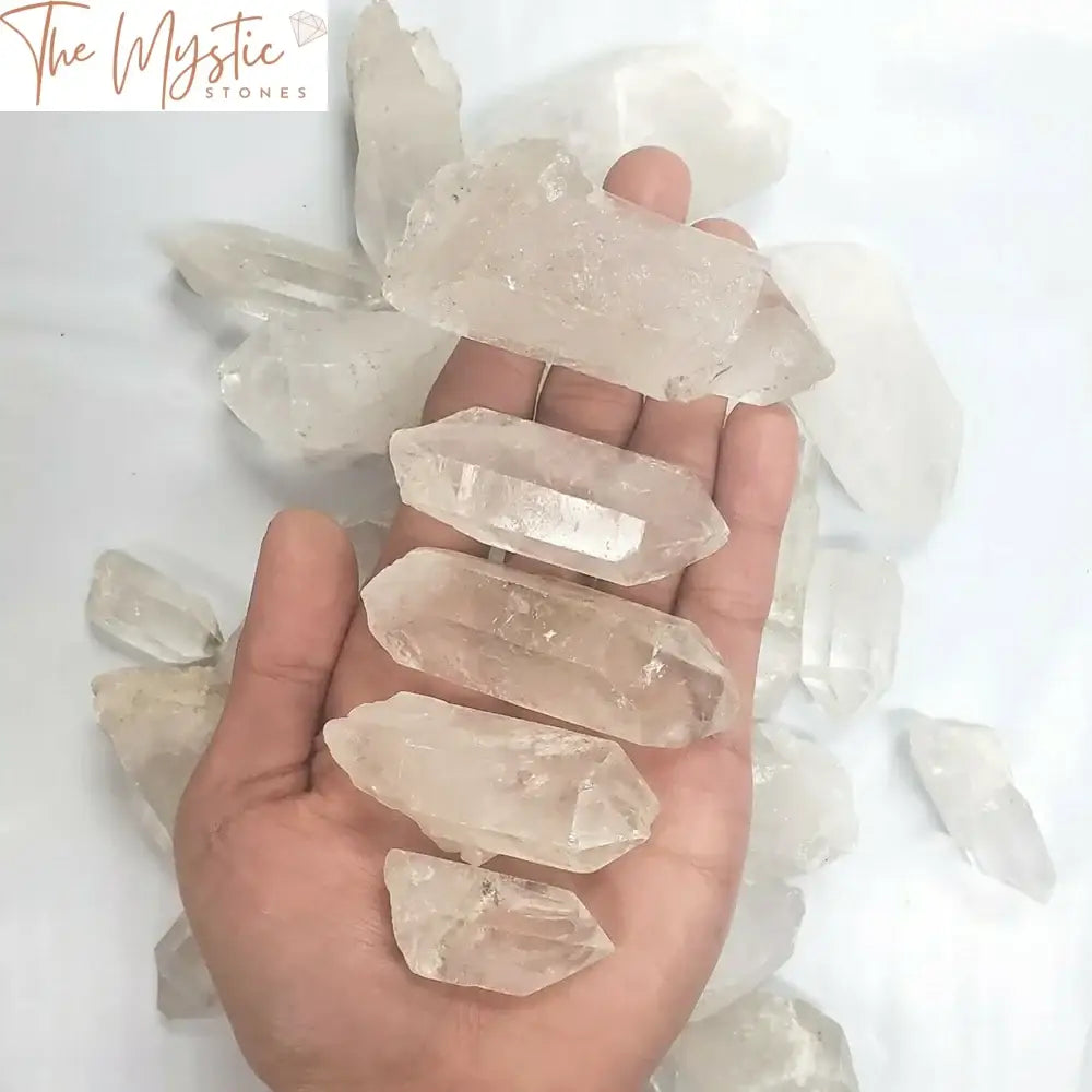 A collection of natural white quartz crystal points arranged together on a neutral background.